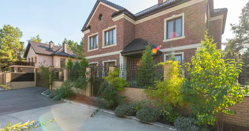 Representative exterior: a bright brick family home with planted frontage and a driveway.
