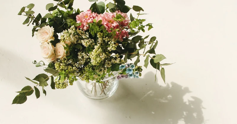 A florist holding a bright hand-tied bouquet in the studio.