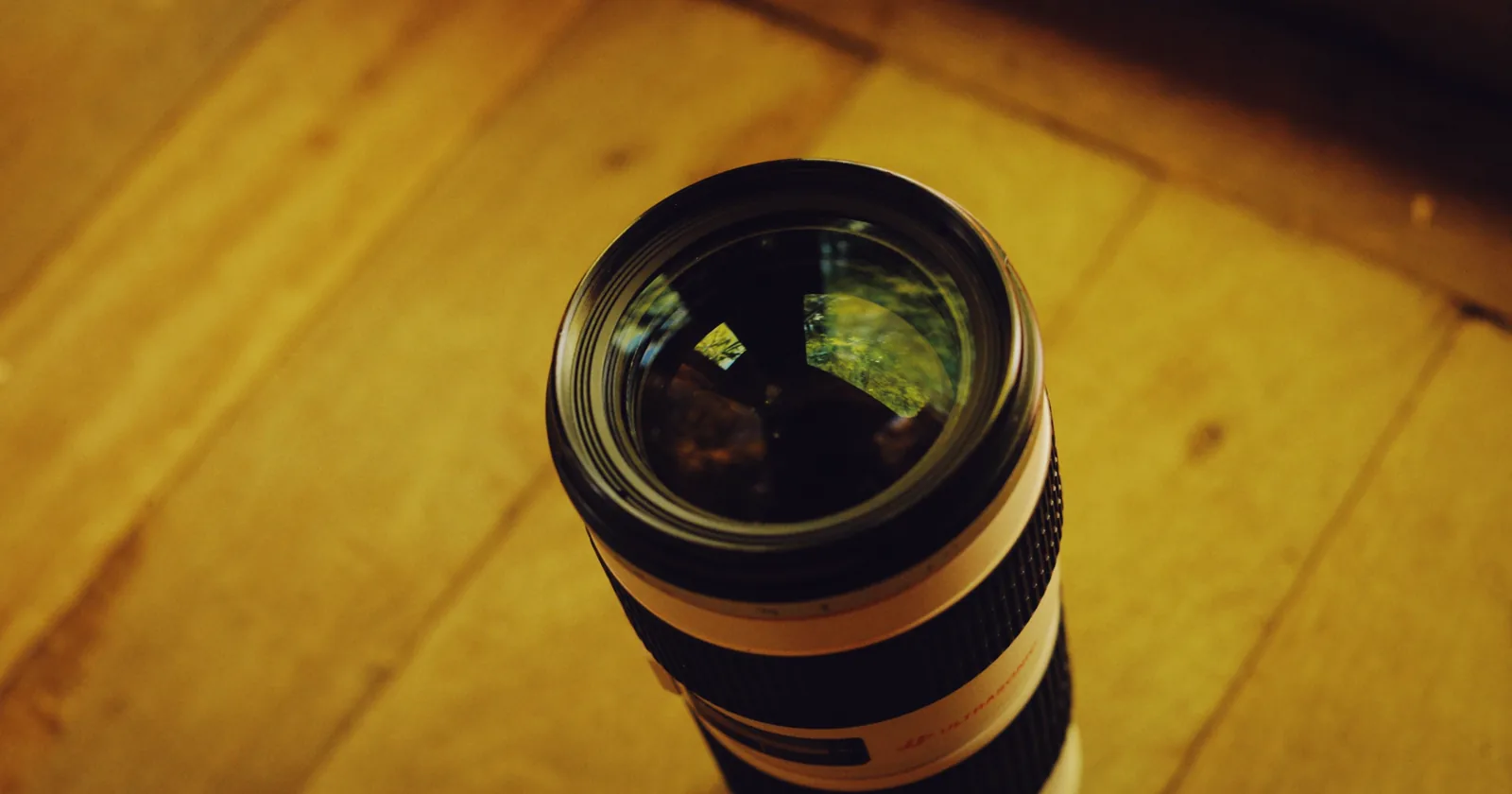 Close detail of a camera lens with reflections across the glass.