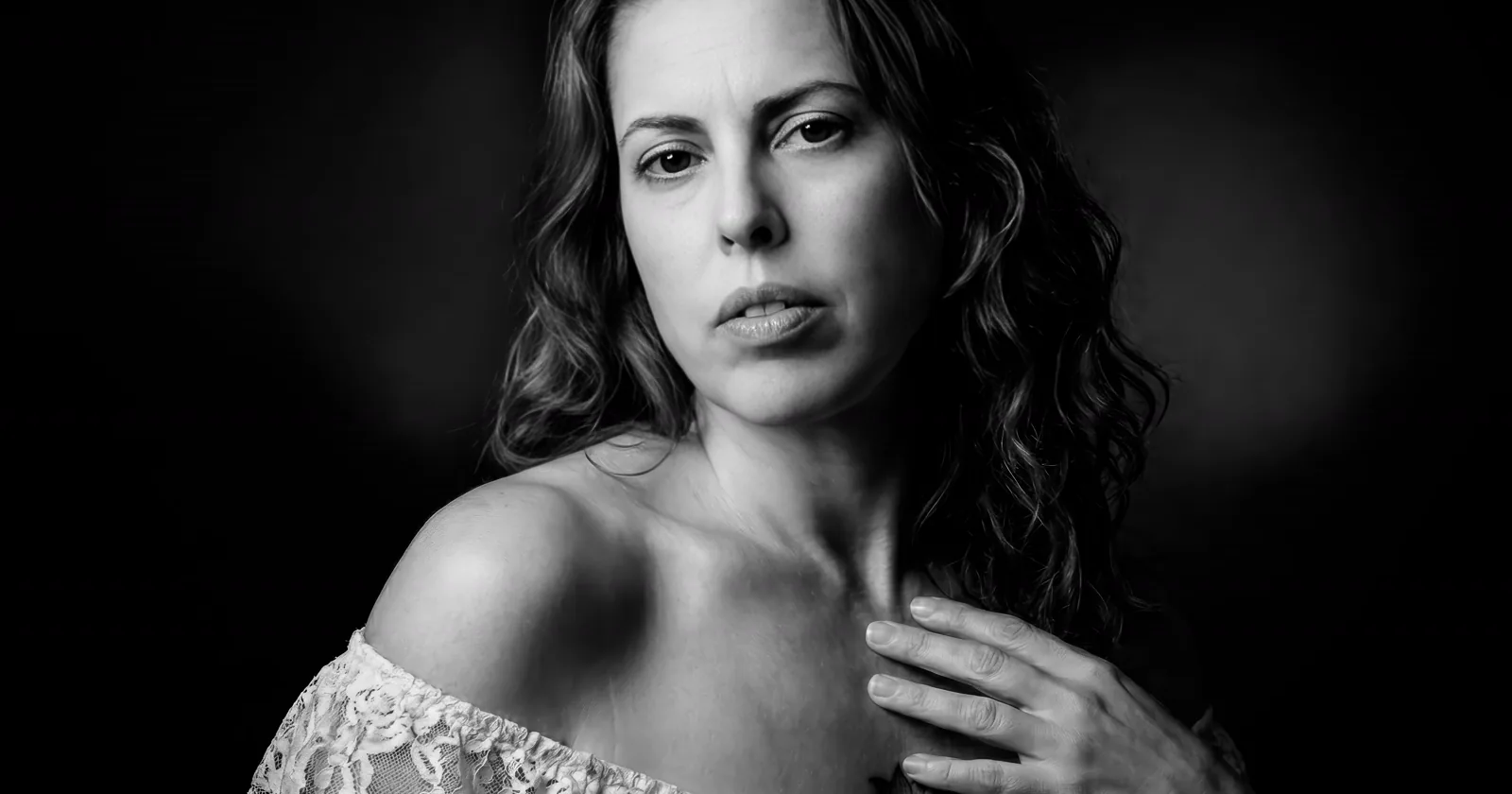 Monochrome portrait of a thoughtful woman in soft side light.