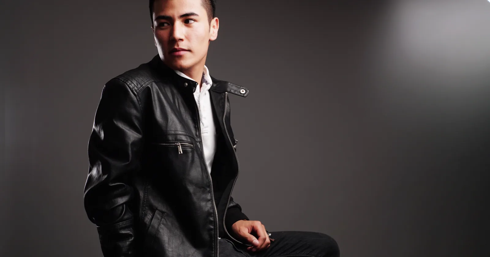 Studio portrait of a man in a dark jacket.