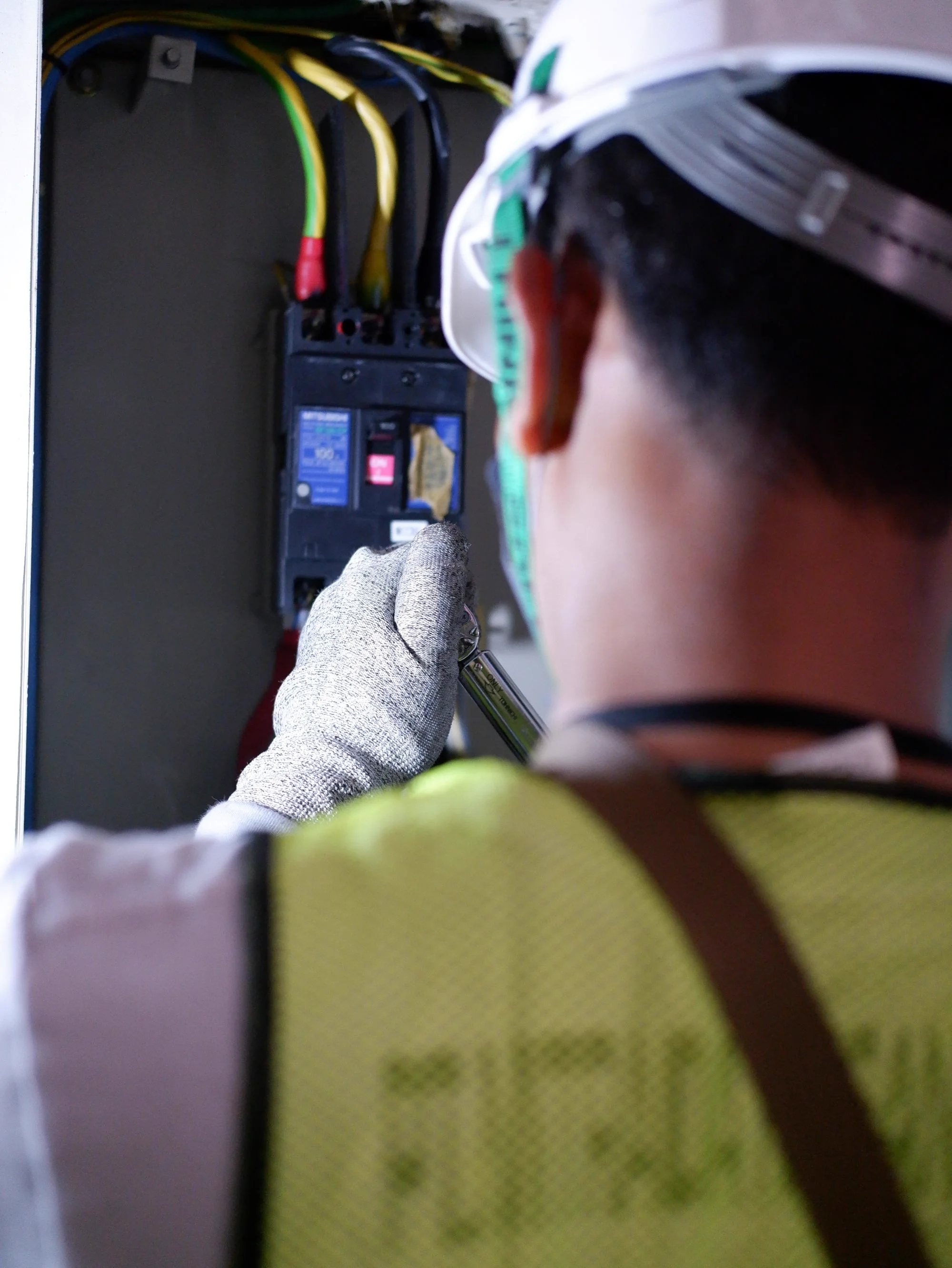Representative electrician work at a breaker panel.